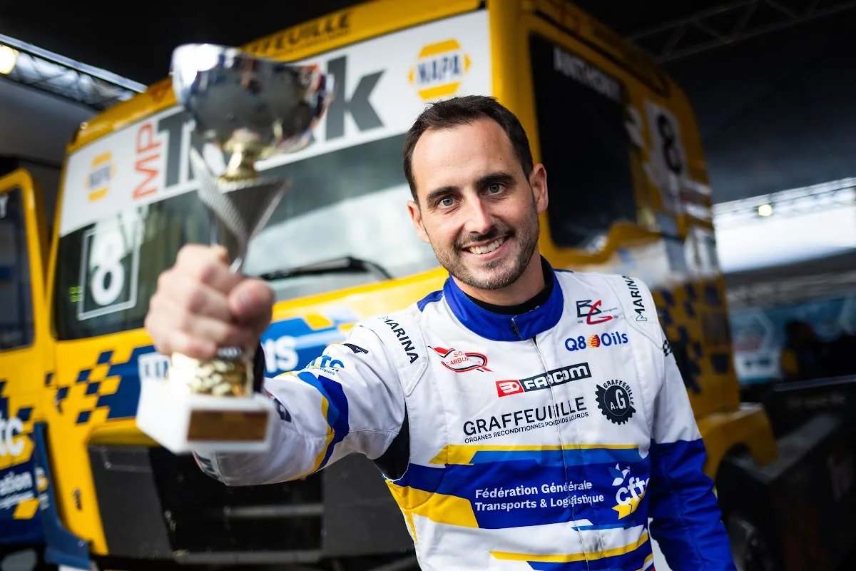 Anthony Robineau tient une coupe devant le camion jaune à Albi